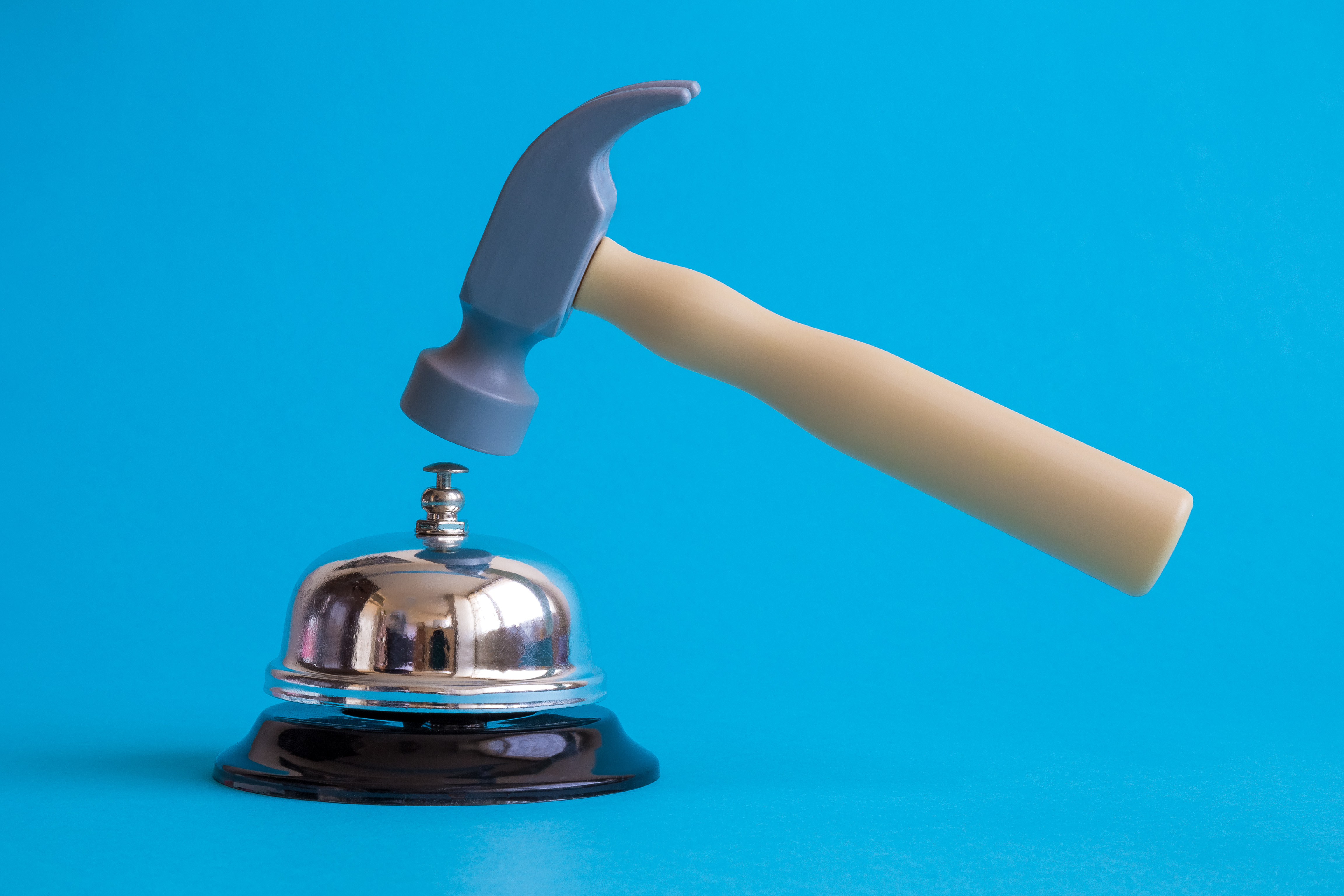 Cloche de service et marteau en plastique sur fond bleu