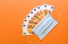 Billets de 50€ et masque chirurgical sur fond orange